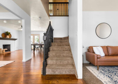 front entry of staged home in orem with stairs and views into office seating area and dining area