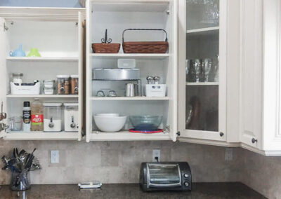 Open kitchen cupboards showcasing dishes and supplies