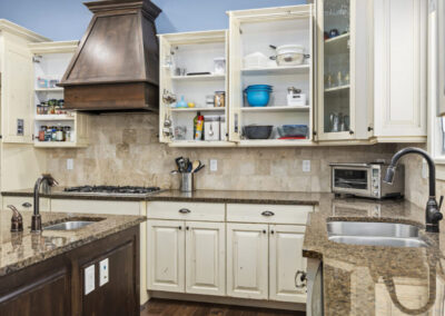 Open kitchen cupboards on a vacation rental furnishing home showing all the organization