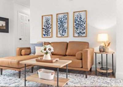 Interior design in Murray includes leather sectional sofa, wooden industrial farmhouse tables and artwork