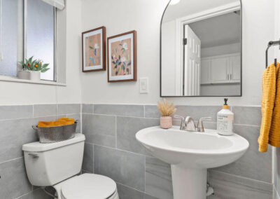 clean modern powder room with yellow towels and artwork