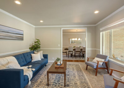 staged sitting room with blue couch and gray armchairs in south jordan ut