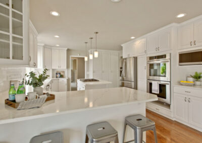 white kitchen staged with grey metal stools and decor