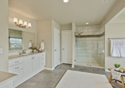 master bathroom with glass shower and staged decorations