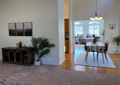 view of several rooms of house staged for sale with credenza, paintings, table, chairs and bedroom set
