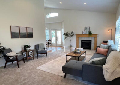 home staging done in living room with fireplace, chairs, sectional sofa and coffee table