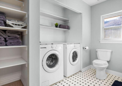 furnished laundry and toilet room with purple towels